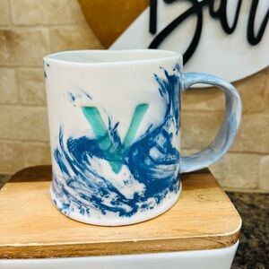 Anthropologie blue marbled coffee mug with the initial V in aqua